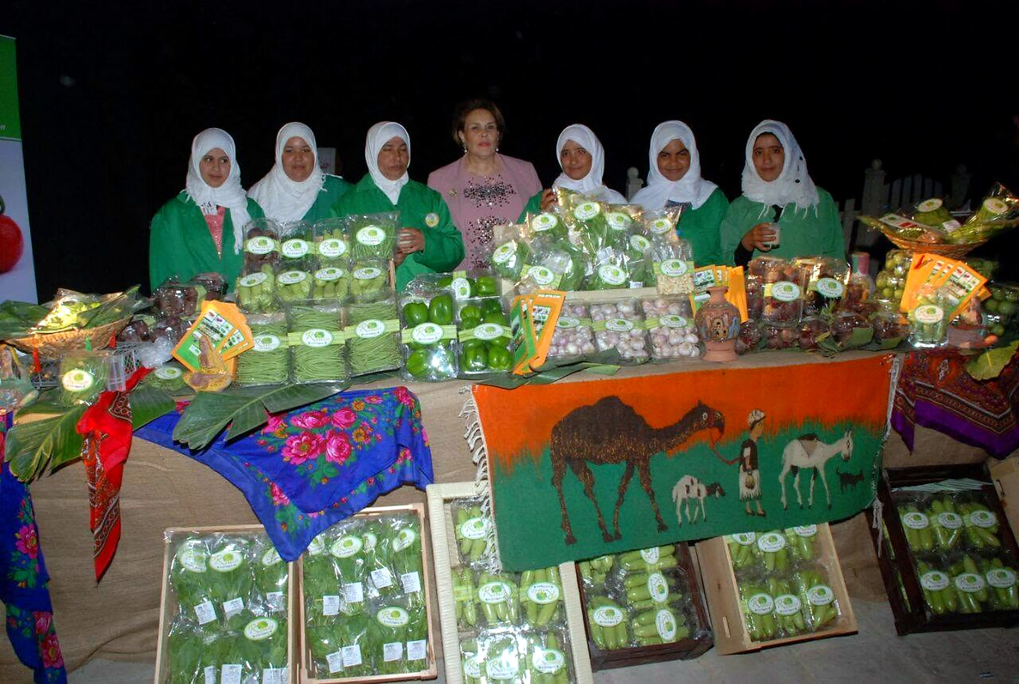 Rawya Mansour with rural women from RAMSCO at a display of the farm's packed organic produce